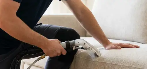 Professional upholstery cleaner deep-cleaning a fabric sofa with a handheld extraction tool, Little Rock, AR.